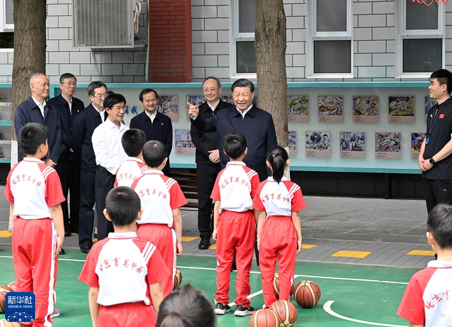  5月31日上午，中共中央总书记、国家主席、中央军委主席习近平来到北京育英学校看望慰问师生，向全国广大少年儿童祝贺“六一”国际儿童节快乐。这是习近平在篮球场同正在上体育课的小学生们亲切交流。新华社记者 申宏 摄