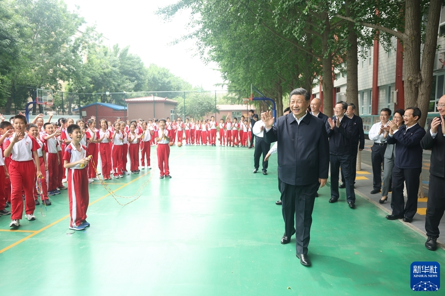  5月31日上午，中共中央总书记、国家主席、中央军委主席习近平来到北京育英学校看望慰问师生，向全国广大少年儿童祝贺“六一”国际儿童节快乐。这是习近平在篮球场向正在上体育课的小学生们挥手致意。新华社记者 鞠鹏 摄